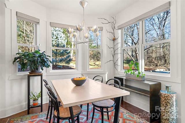 dining area featuring dark wood-type flooring and a notable chandelier