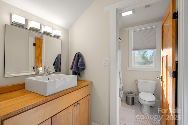 bathroom with vanity, tile patterned flooring, lofted ceiling, and toilet