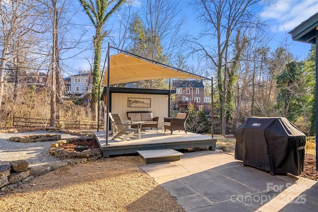 view of patio with area for grilling, a wooden deck, and an outdoor living space