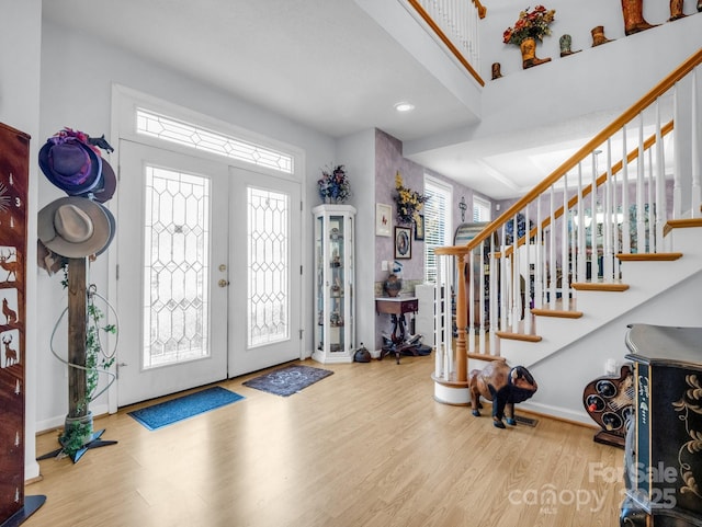 foyer with french doors, a healthy amount of sunlight, and wood-type flooring