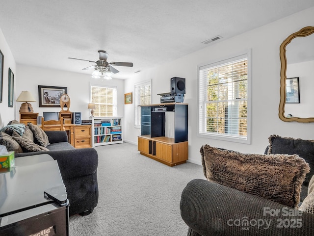 carpeted living room with ceiling fan