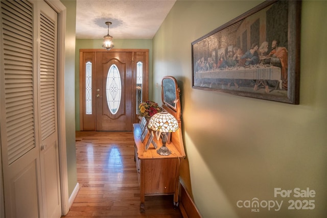 entryway with wood-type flooring and a textured ceiling