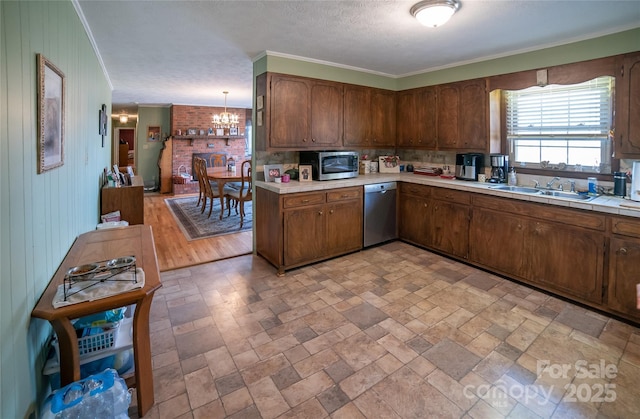 kitchen featuring sink, crown molding, decorative light fixtures, a chandelier, and stainless steel appliances