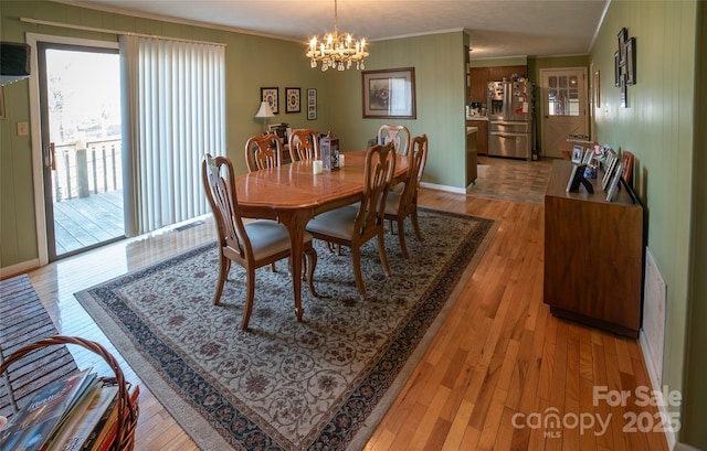 dining room with ornamental molding, a chandelier, and light wood-type flooring