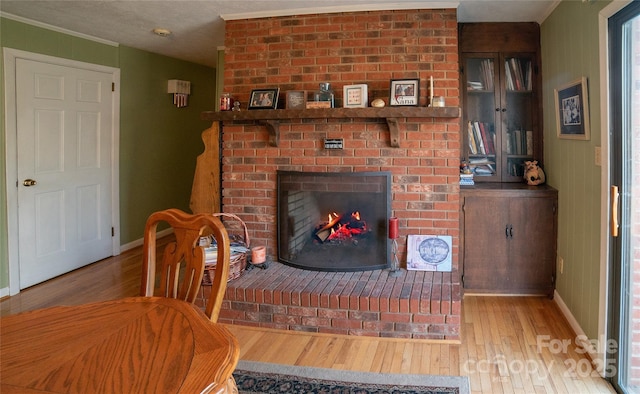 unfurnished living room with a brick fireplace and light hardwood / wood-style flooring