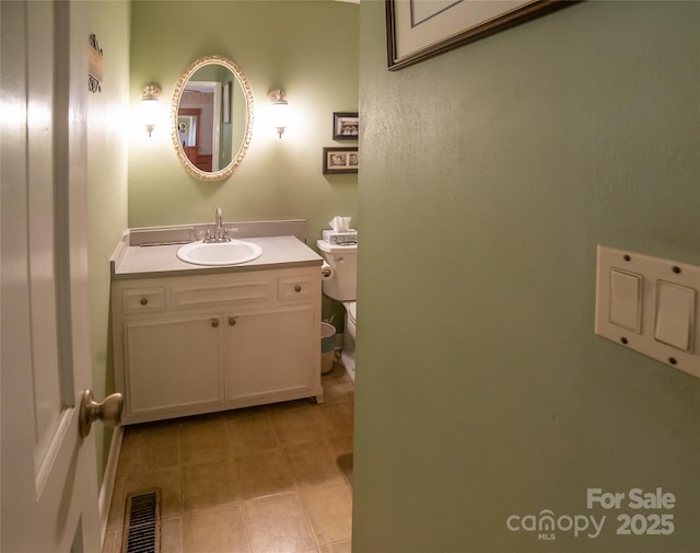 bathroom featuring vanity, tile patterned floors, and toilet