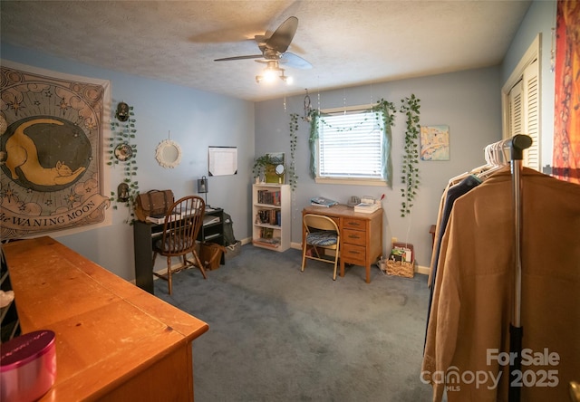 carpeted office featuring ceiling fan and a textured ceiling