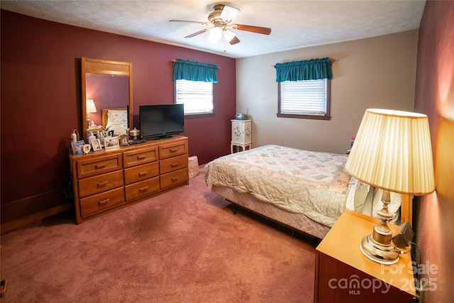 carpeted bedroom with ceiling fan and a textured ceiling