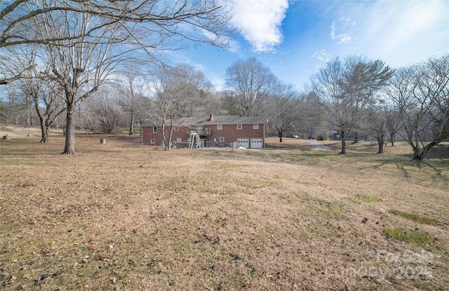 view of yard with a garage and a rural view