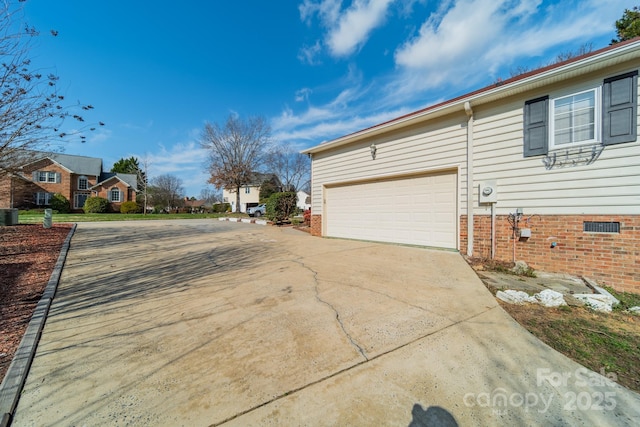 view of home's exterior with crawl space, a residential view, a garage, and driveway