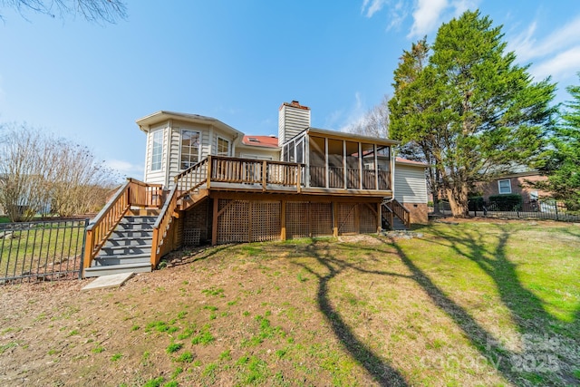 rear view of house with stairway, fence, a yard, a sunroom, and a chimney
