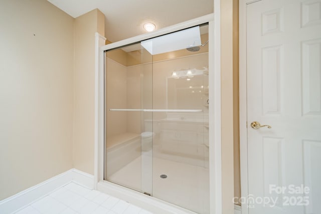 bathroom featuring tile patterned floors, a stall shower, and baseboards