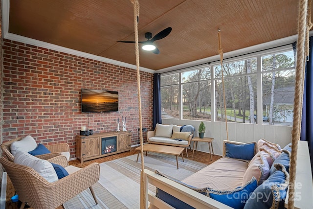 sunroom with a wealth of natural light, a glass covered fireplace, and wood ceiling