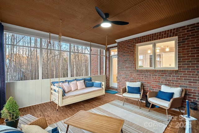 sunroom featuring ceiling fan and wooden ceiling