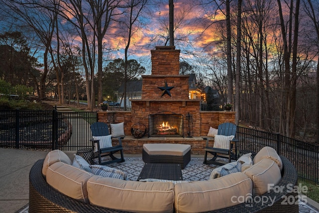 patio terrace at dusk featuring an outdoor living space with a fireplace