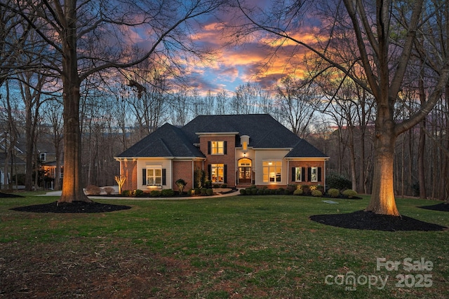 view of front facade featuring a front yard and brick siding