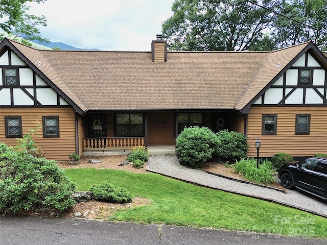 tudor home featuring a front lawn