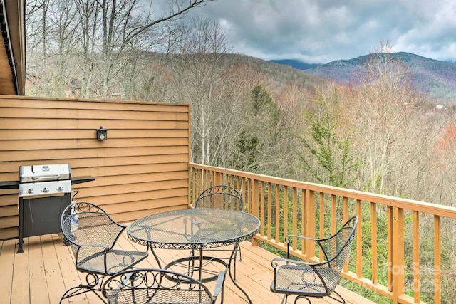 wooden deck featuring a mountain view and a grill