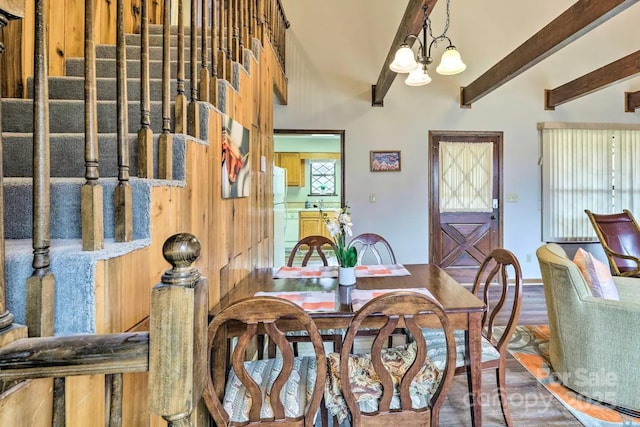 dining room featuring hardwood / wood-style floors, beamed ceiling, and a chandelier