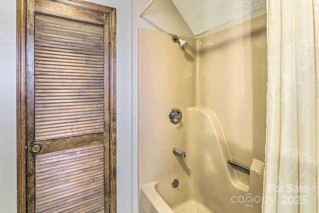 bathroom featuring shower / bath combo and vaulted ceiling