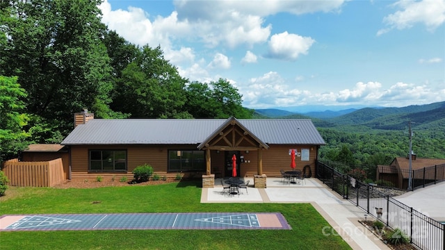 view of front of house featuring a mountain view and a front lawn