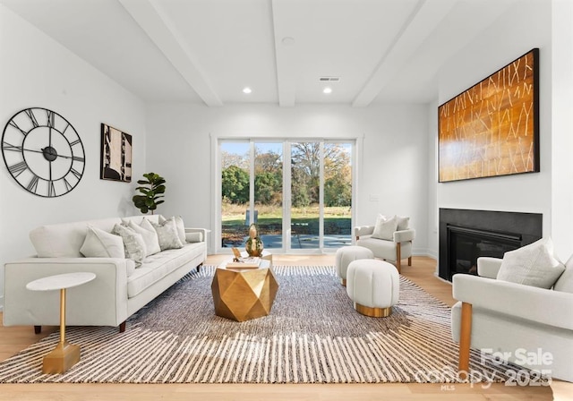 living room with beam ceiling and wood-type flooring