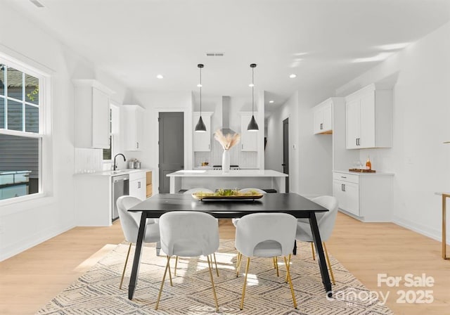 dining space with light hardwood / wood-style flooring and sink