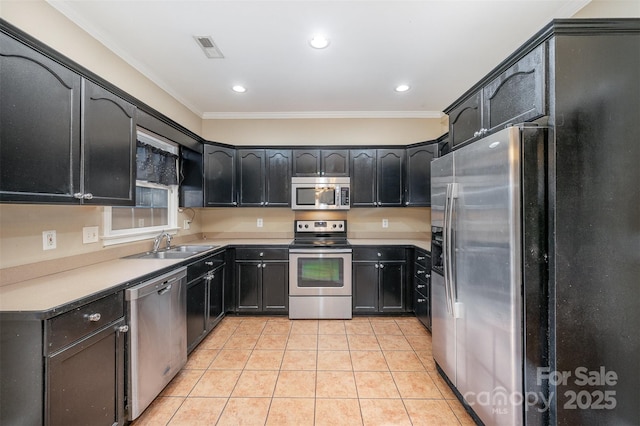 kitchen with crown molding, light tile patterned floors, stainless steel appliances, and sink