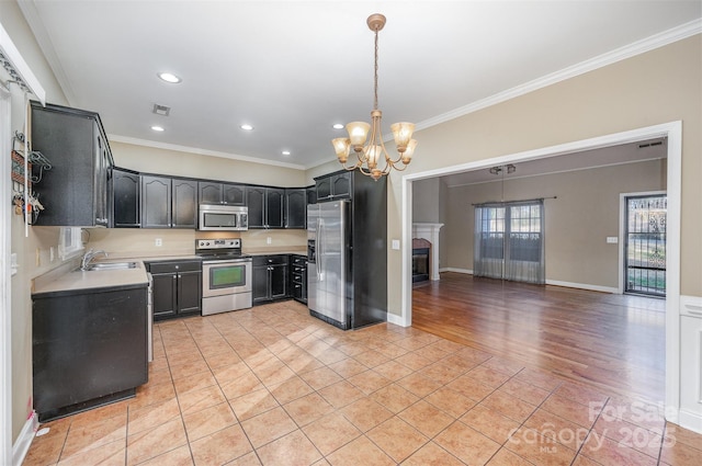 kitchen with sink, appliances with stainless steel finishes, crown molding, and pendant lighting