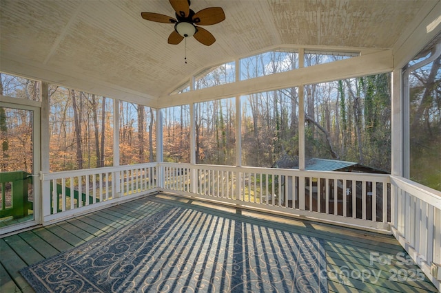 unfurnished sunroom with vaulted ceiling, ceiling fan, and plenty of natural light