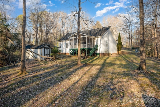 view of yard featuring a storage unit and a sunroom