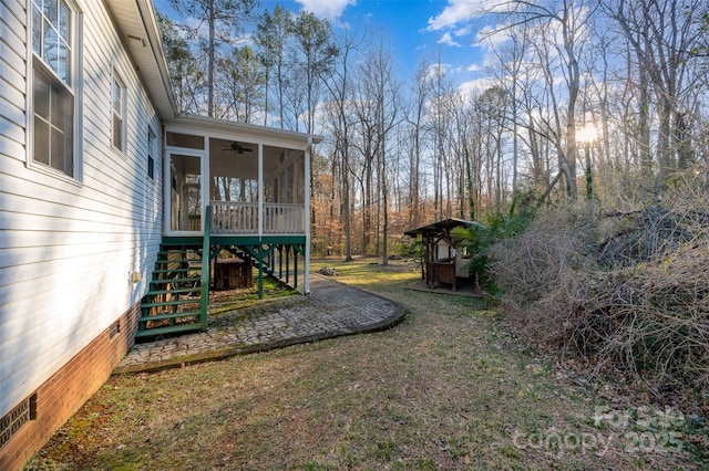 view of yard with a sunroom and ceiling fan