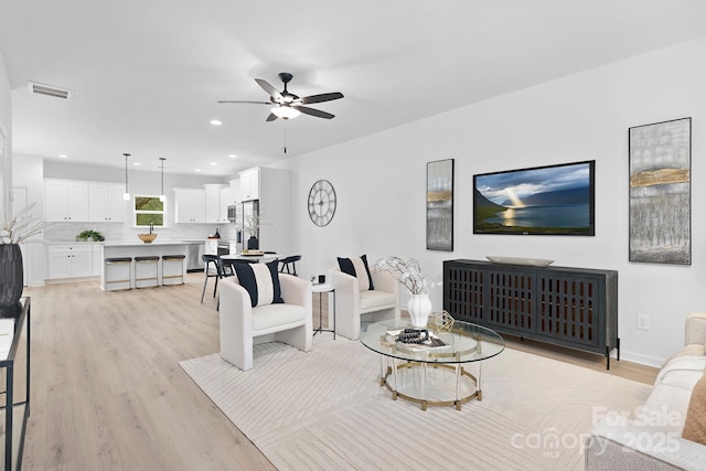 living area featuring recessed lighting, visible vents, light wood-style flooring, and a ceiling fan