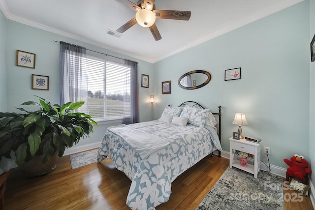 bedroom with crown molding, ceiling fan, and dark hardwood / wood-style floors