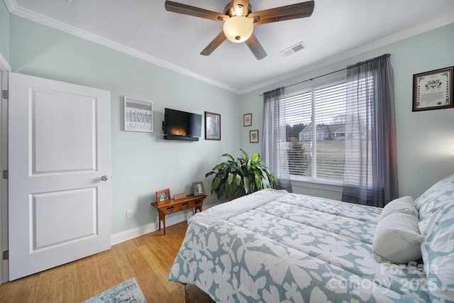 bedroom featuring crown molding, light hardwood / wood-style floors, and ceiling fan