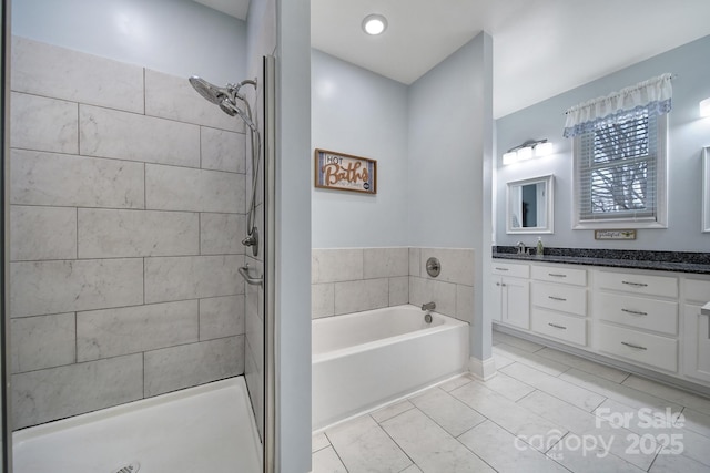 bathroom with vanity and shower with separate bathtub