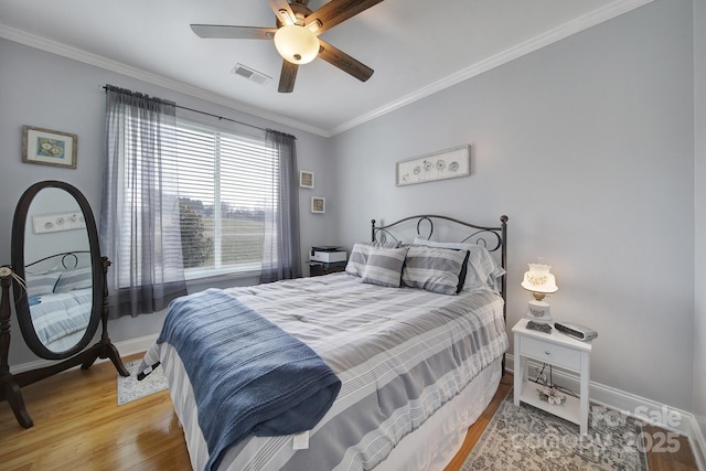 bedroom featuring crown molding, ceiling fan, and wood-type flooring