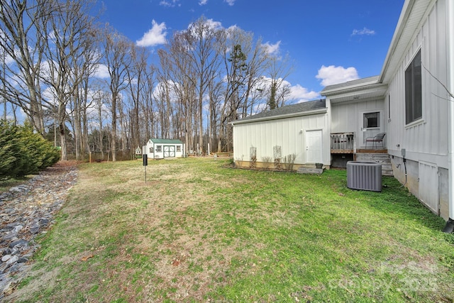 view of yard with a storage shed and central air condition unit