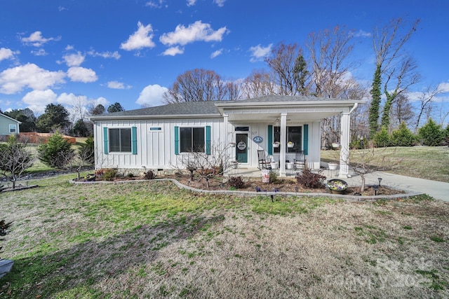 view of front of home with covered porch and a front lawn