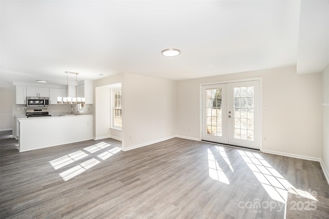 unfurnished living room with light wood-type flooring and french doors