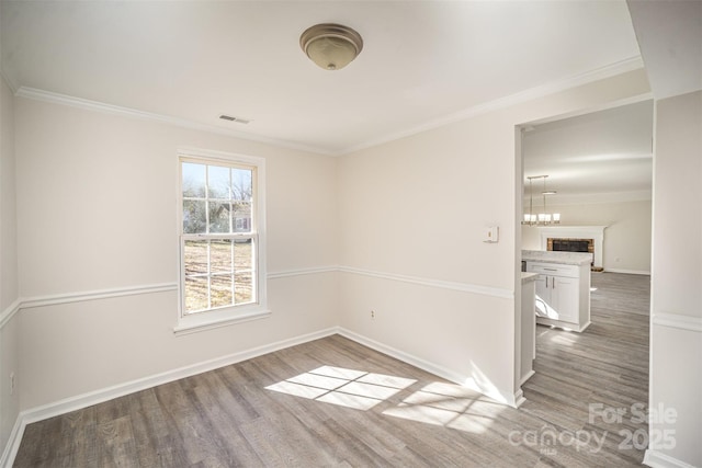 spare room with wood-type flooring and ornamental molding