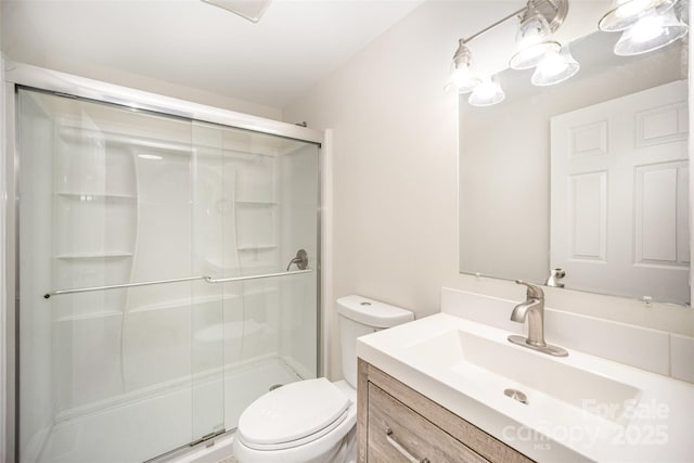 bathroom featuring vanity, toilet, and a shower with door