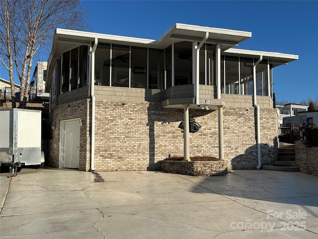 view of side of property featuring a garage and a sunroom