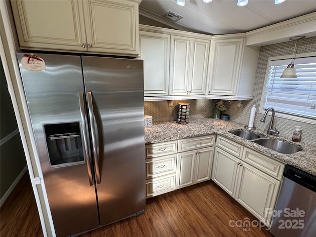 kitchen with sink, appliances with stainless steel finishes, dark hardwood / wood-style floors, light stone counters, and cream cabinetry