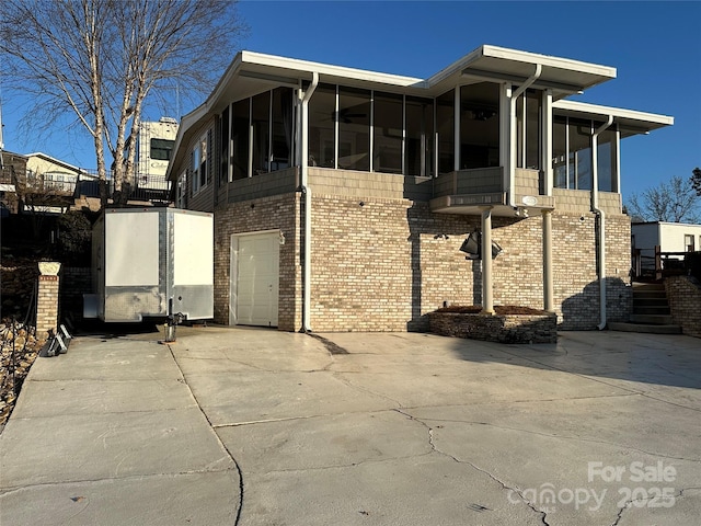 view of front of home with a garage and a sunroom