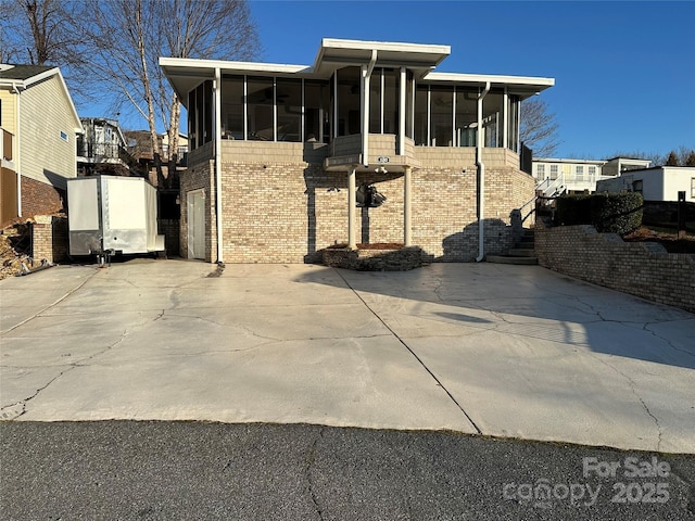 view of front of home featuring a garage and a sunroom