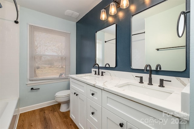 full bathroom with wood-type flooring, shower / washtub combination, vanity, and toilet