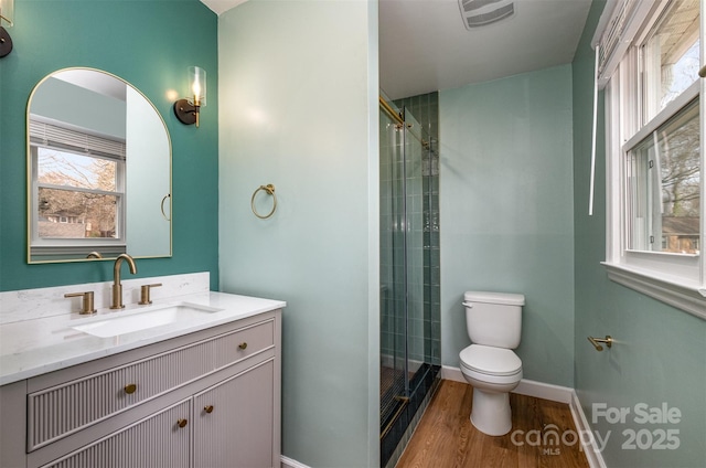 bathroom featuring vanity, hardwood / wood-style floors, an enclosed shower, and toilet