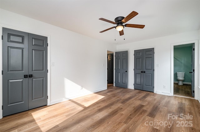 unfurnished bedroom with ceiling fan, hardwood / wood-style floors, and ensuite bath