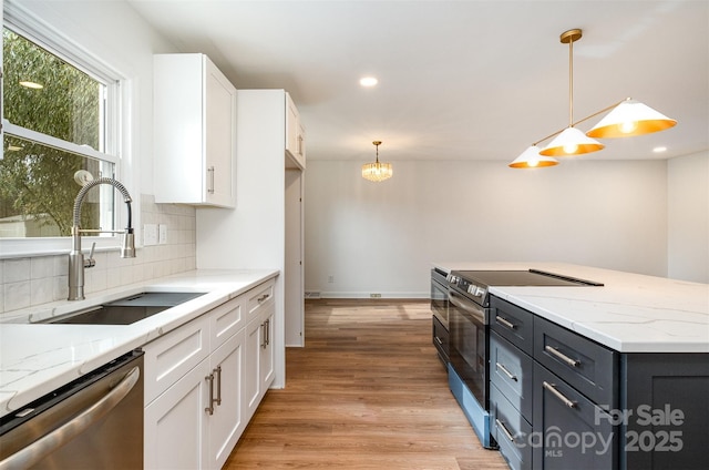 kitchen featuring white cabinetry, stainless steel appliances, sink, and pendant lighting